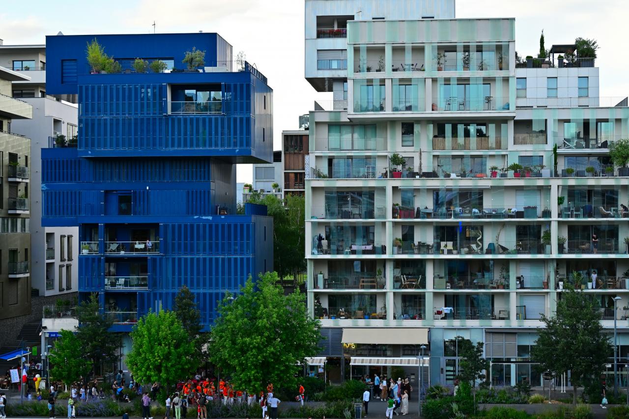 A group of people standing in front of a blue building
